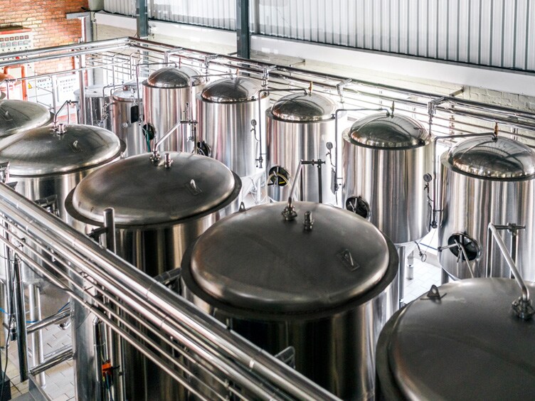 Rows of brewery tanks in a food processing space