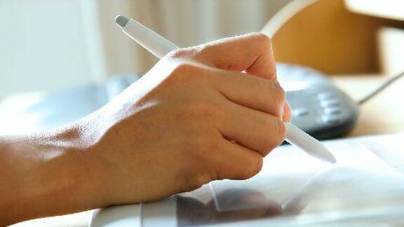 Close-up shot of a person using a stylus on a device