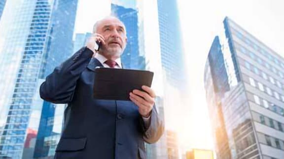 Man in business formals speaking on his smartphone