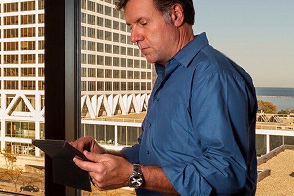 Man using a tablet near a glass window